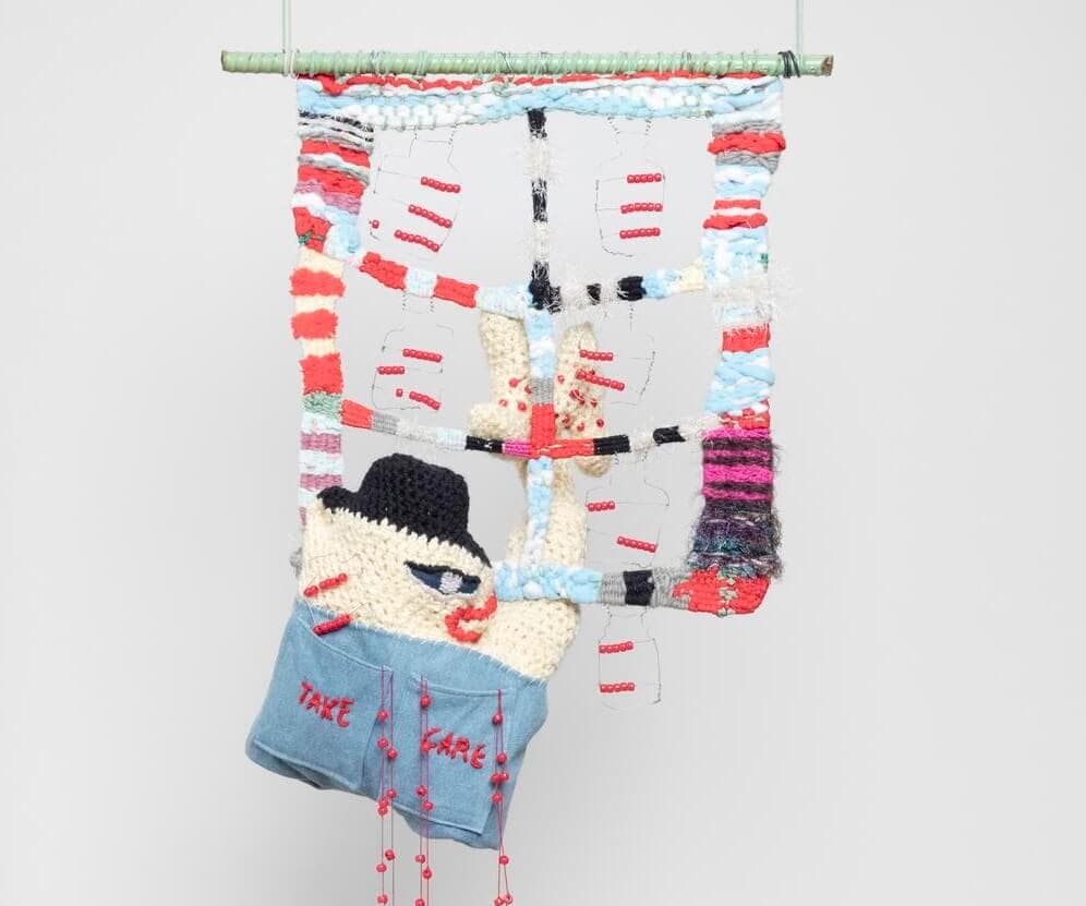 Object view of a hanging sculpture made of yarn, wire, beads, and rope.